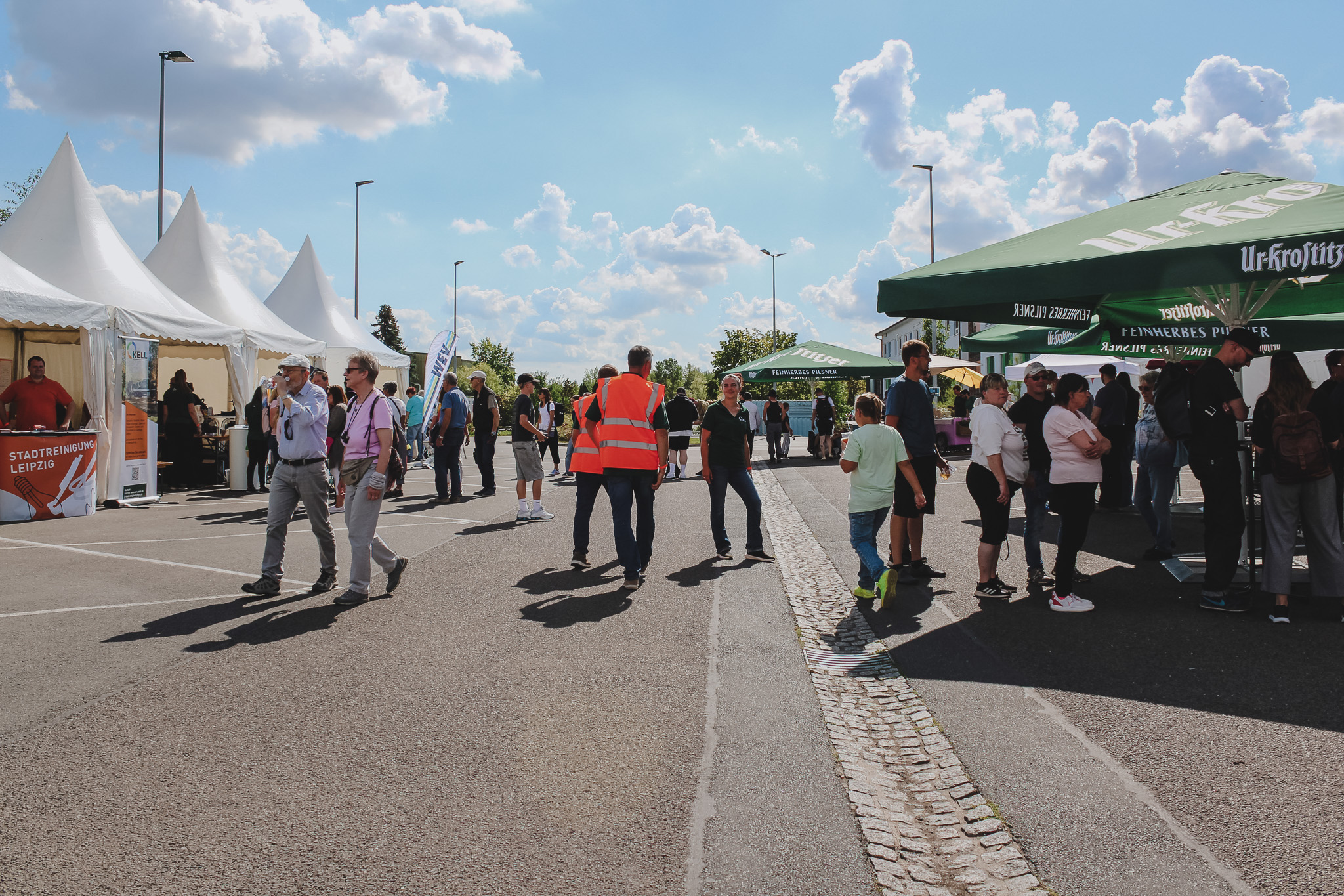 Tag der offenen Tür 2025 Besucher beim Tag der offenen Tür 2025: Menschen, Zelte, Imbissstände unter blauem Himmel.