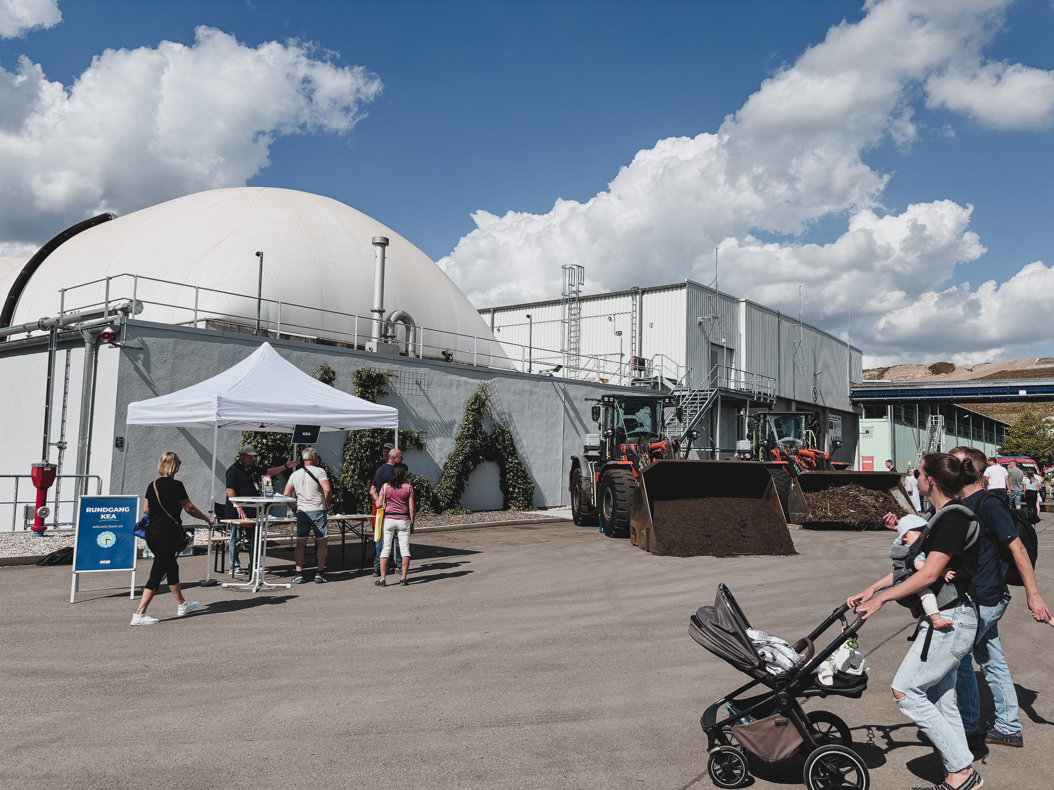 Tag der offenen Tür 2025 Tag der offenen Tür: Biogasanlage mit Besuchern, Radladern und Infostand. "Rundgang KEA" Schild.