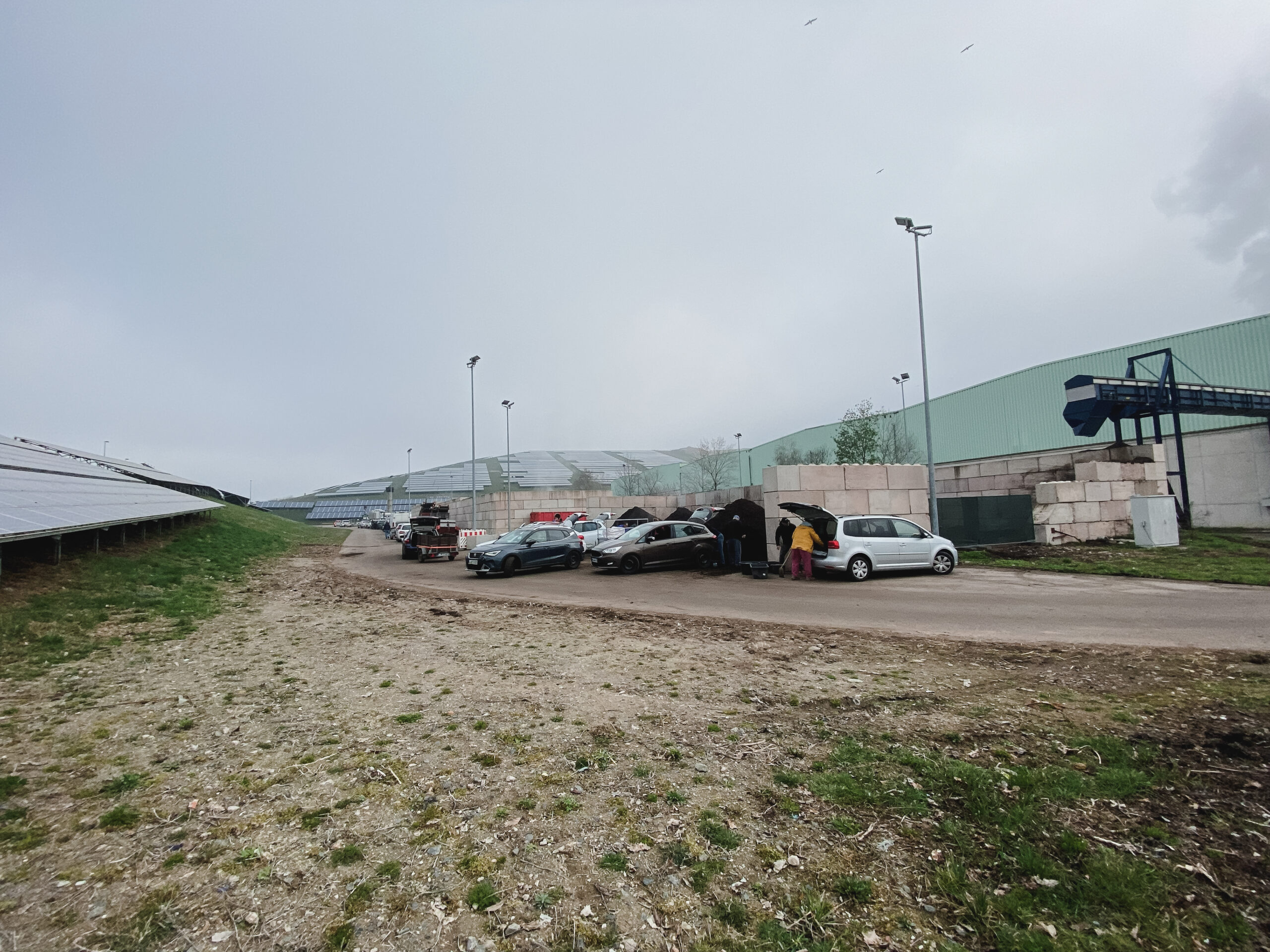 Komposttag 2026 Autos beim Komposttag: Menschen laden Kompost in ihre Fahrzeuge.